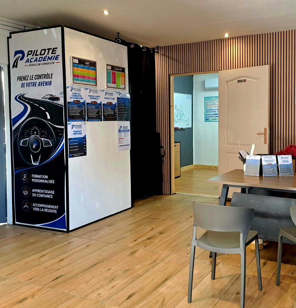 Espace d'accueil de l'agence avec le bureau et les affiches des forfaits